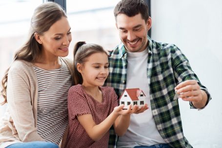 Der Hausbau Berater - Fachberater für Fertighäuser - Thomas Bärtle Familie mit einem kleinen Modellhaus, das ein Mädchen stolz hält.